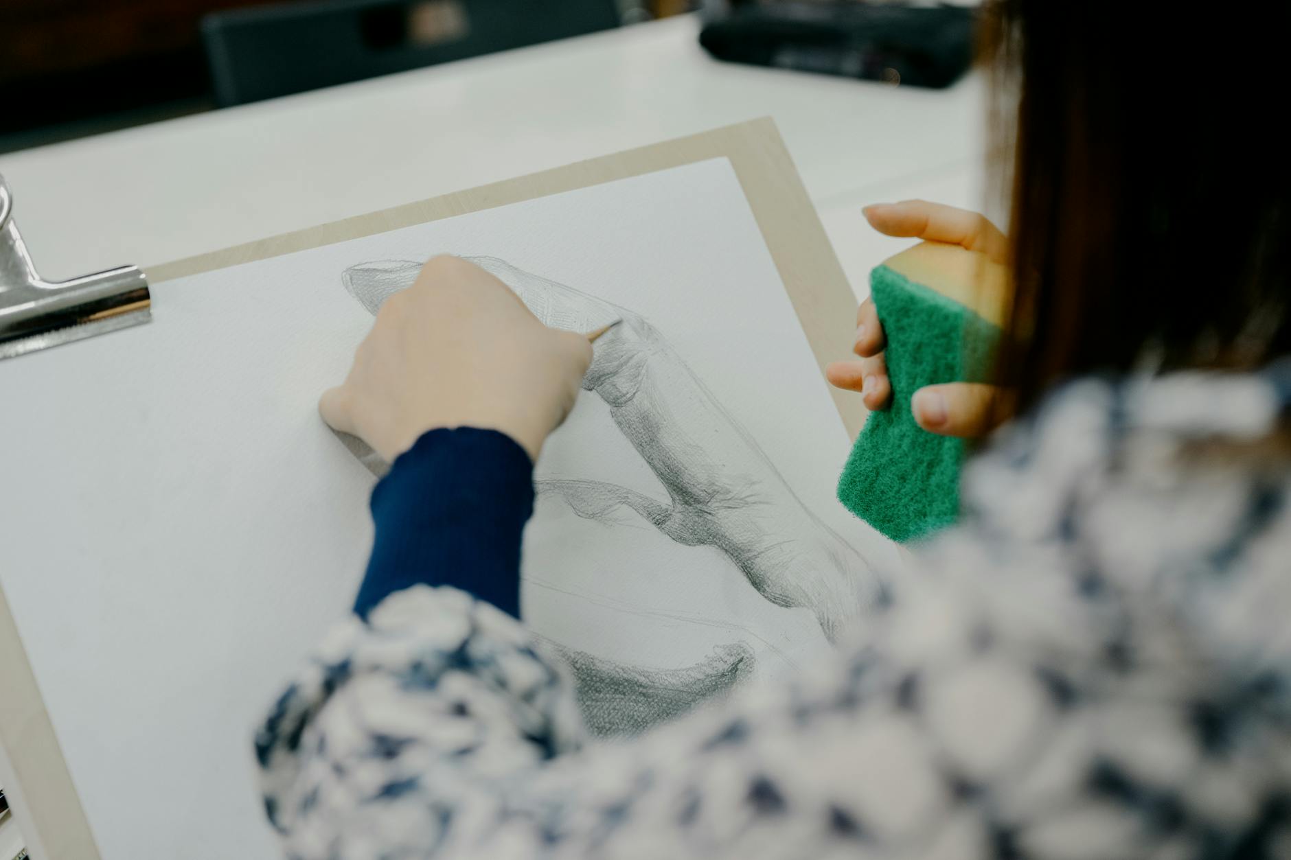 Artysta szkicuje dłoń ołówkiem w pracowni plastycznej w Tokio