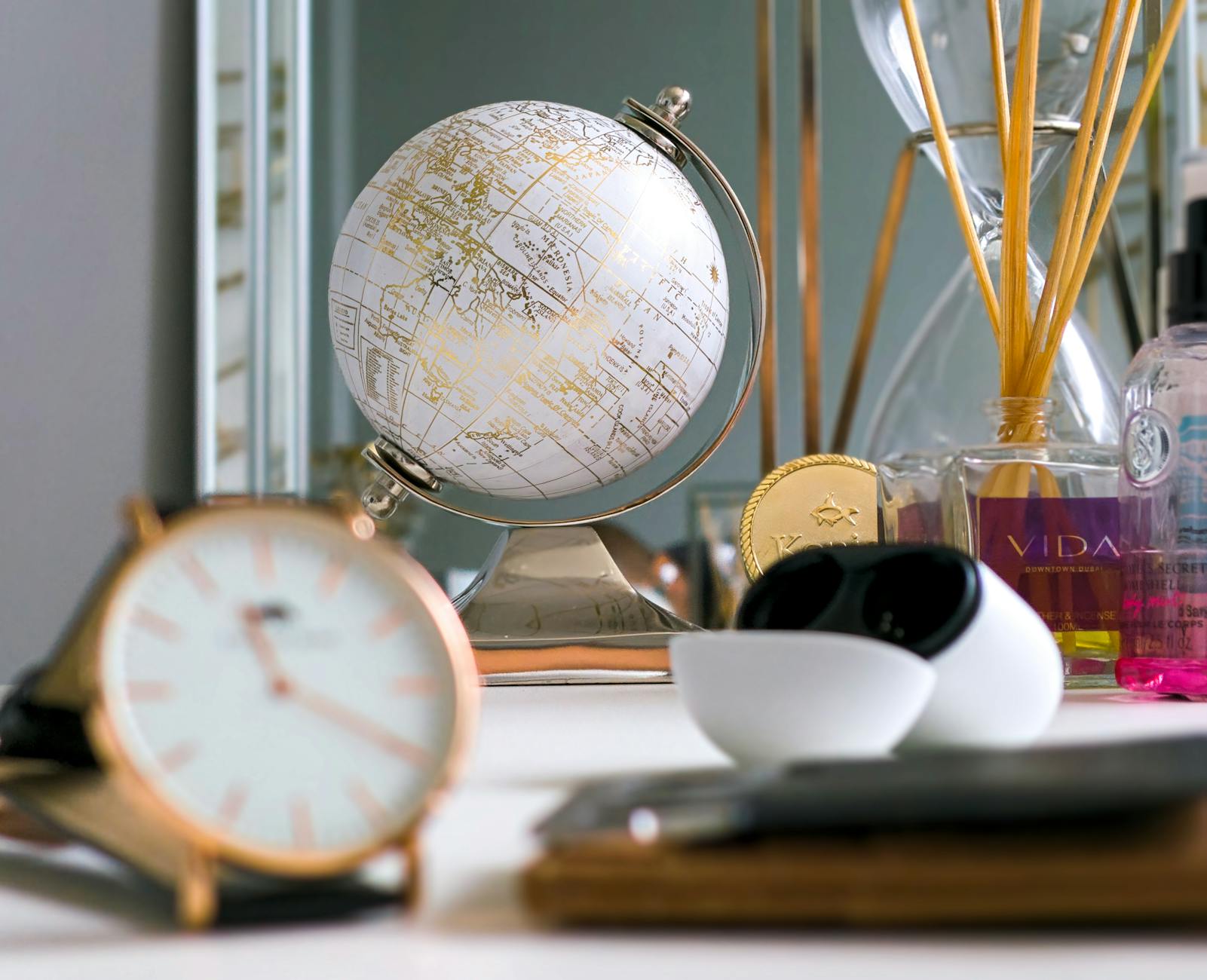 Glob i zegar na nowoczesnym biurku jako symbol różnych stref czasowych