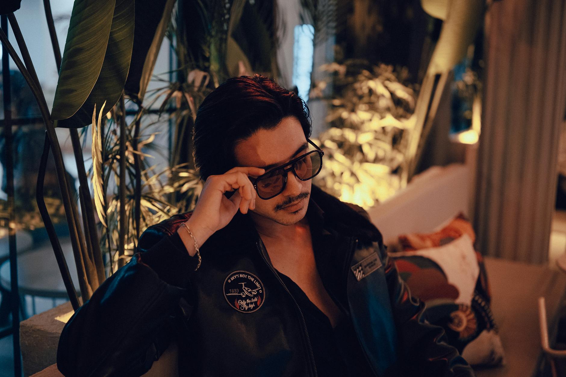 Młody mężczyzna w okularach przeciwsłonecznych relaksuje się w ciepłym wnętrzu