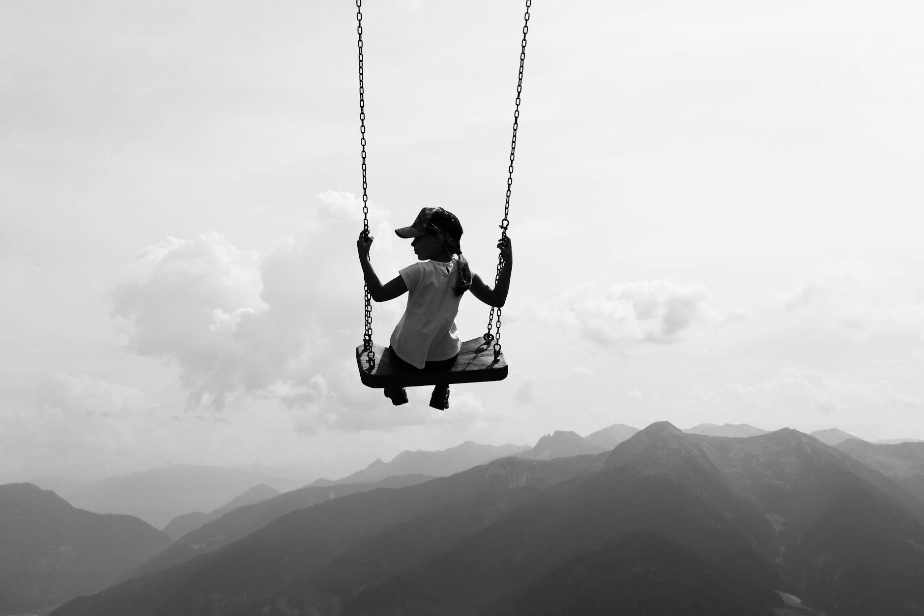 Kobieta na huśtawce wysoko nad górskim krajobrazem we Włoszech