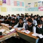 Uczniowie szkoły średniej słuchają i notują podczas lekcji przedsiębiorczości