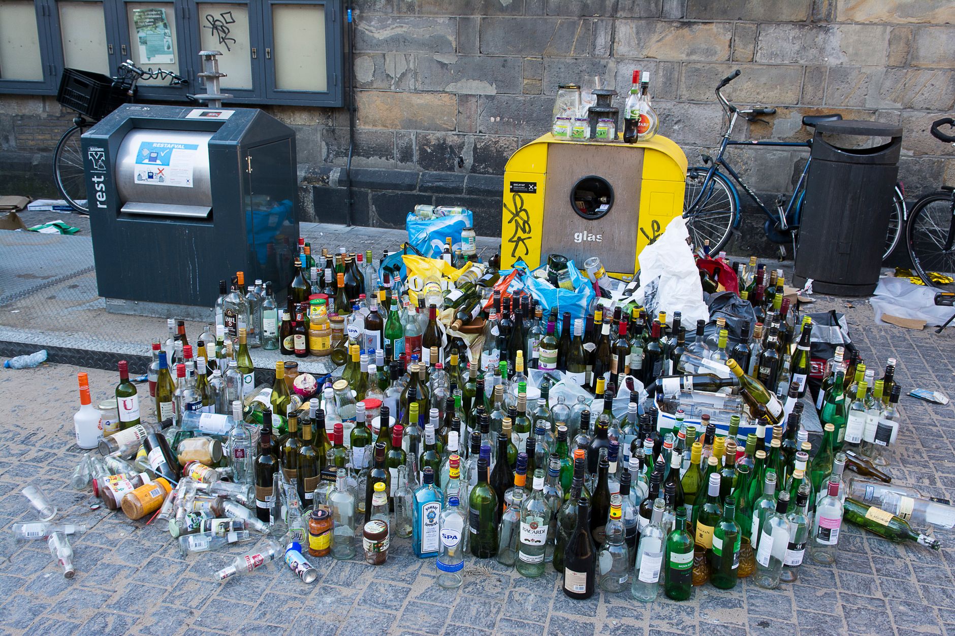 Sterta szklanych butelek do recyklingu na miejskiej ulicy